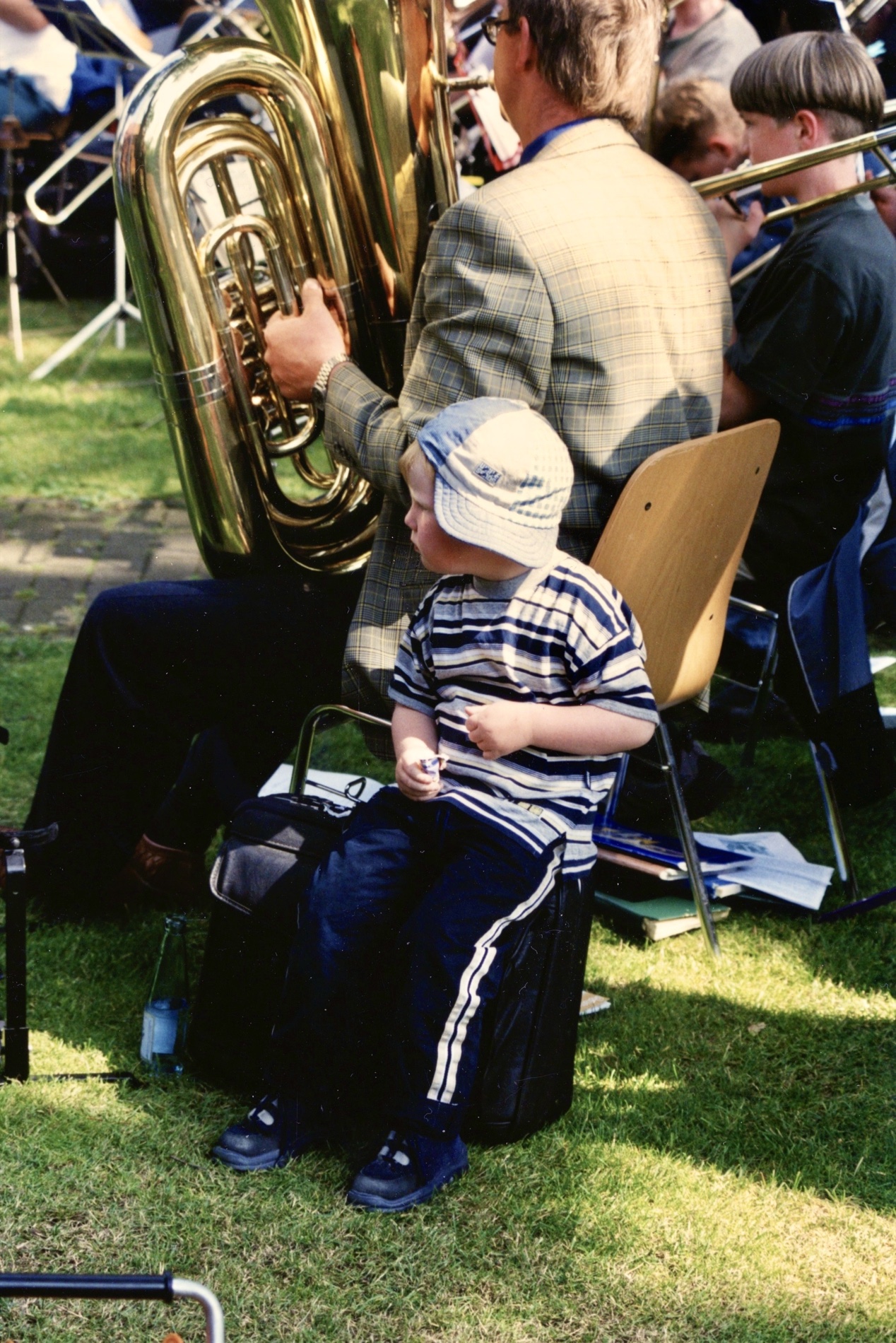 Ein Kind sitzt zwischen Musikerinnen und Musikern des Posaunenchors